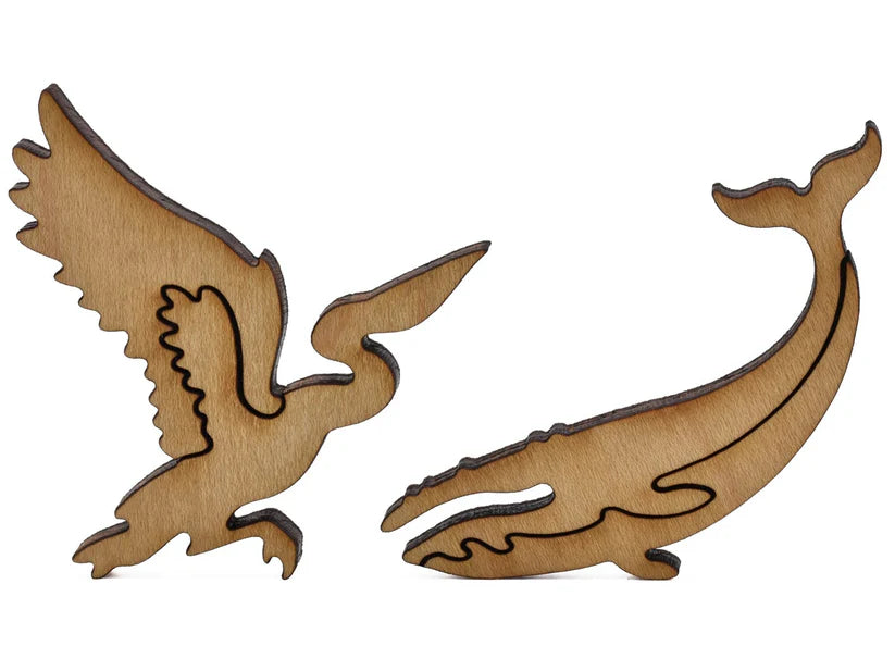 Distinctive wooden silhouette puzzle pieces of a heron and whale from the Cape Cod Xplorer Map Wooden Puzzle by Liberty Puzzles.
