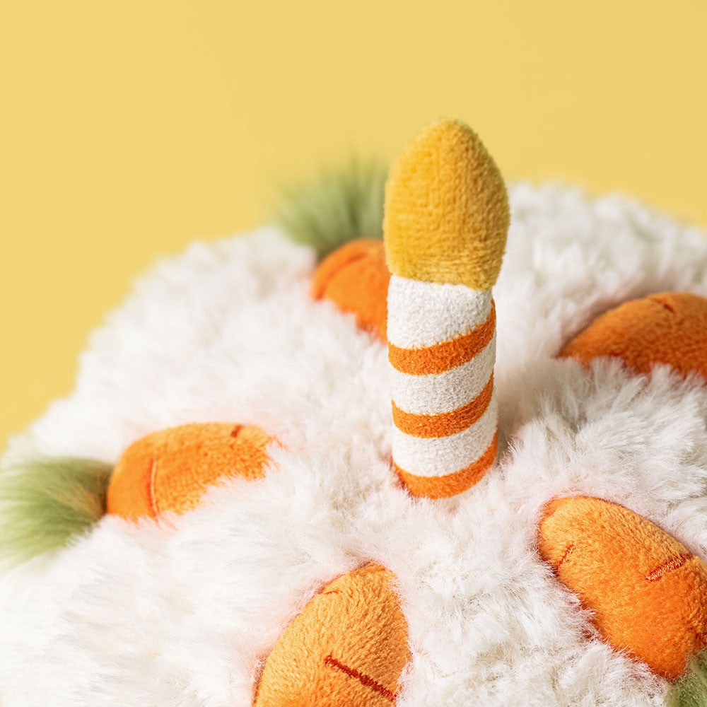 Top view of Amusables Carrot Cake by JellyCat focusing on the cute candle and colorful carrot decorations on the fluffy icing.