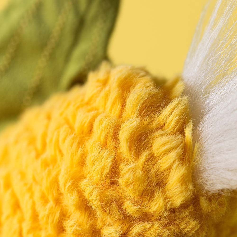 Amusables Sweetcorn sitting upright, highlighting its dimensions and fluffy polyester material.