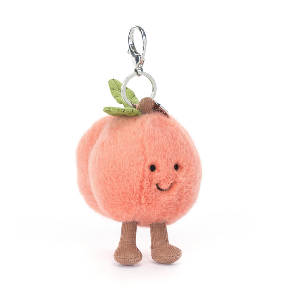 Cute Amuseables Peach Bag Charm by JellyCat with a smiling face and small legs, perfect for adding a fun touch to your bag.