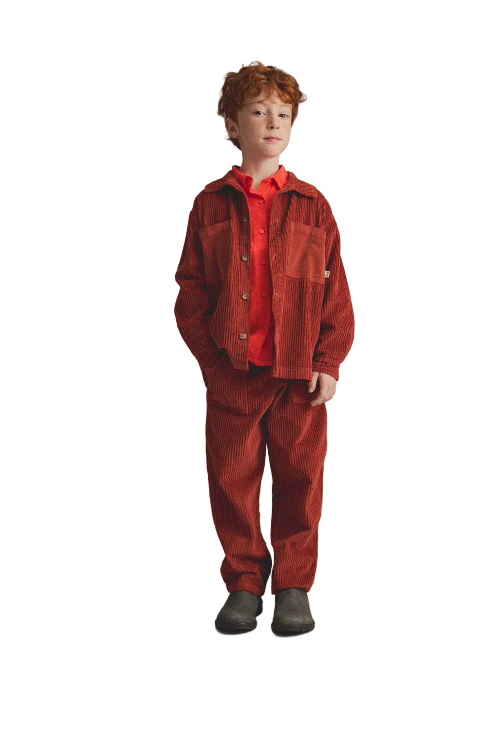 Child wearing a red outfit against a gray background