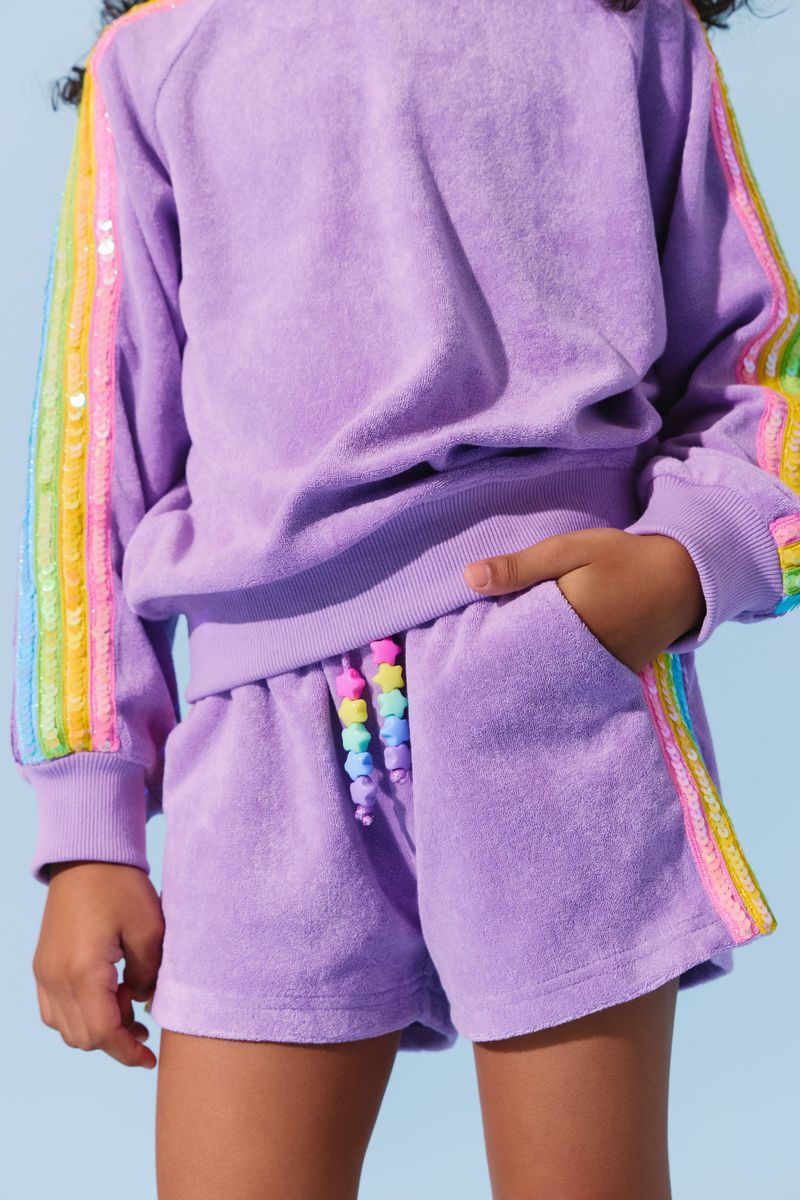 Kid wearing the Lavender Rainbow Sequin Stripe Short Set from Lola and the Boys, featuring colorful sequin stripes on sleeves and matching shorts, perfect for a stylish day out.