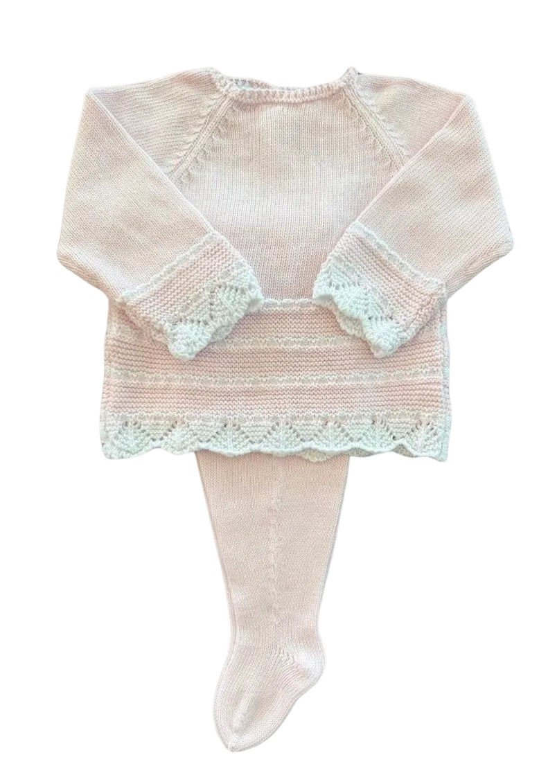 A baby knit outfit consisting of a long-sleeve top in pale pink with white lace trim on the cuffs and hem, paired with matching pale pink tights, shown on a plain white background.