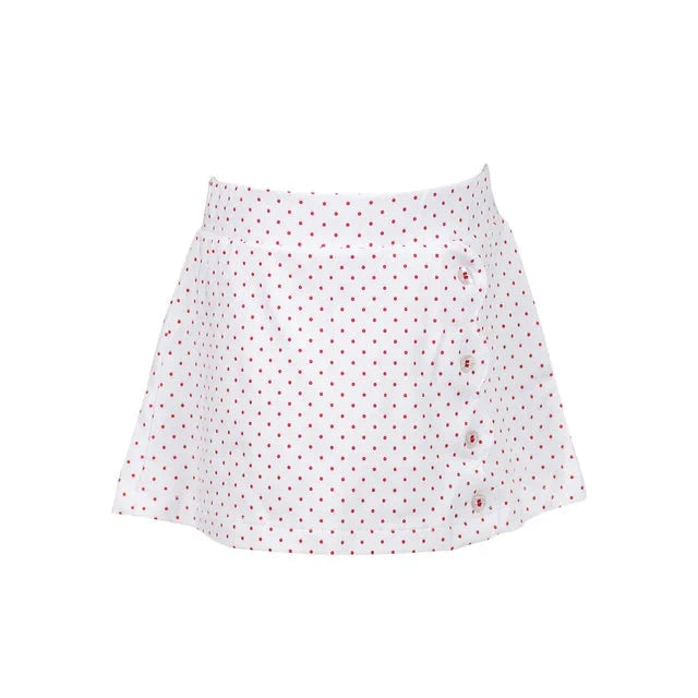 Front view of the Dottie Skort from The Proper Peony, showcasing its playful polka dot pattern in red on a white background, perfect for summer fashion.