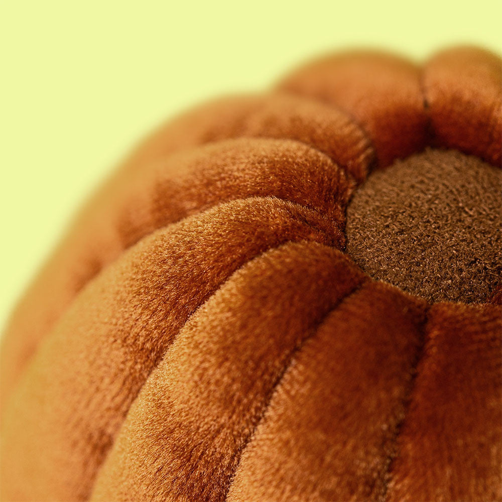 Close-up of the top of Amuseables Carole Canelé plush by JellyCat, capturing the soft, velvety texture and warm color.