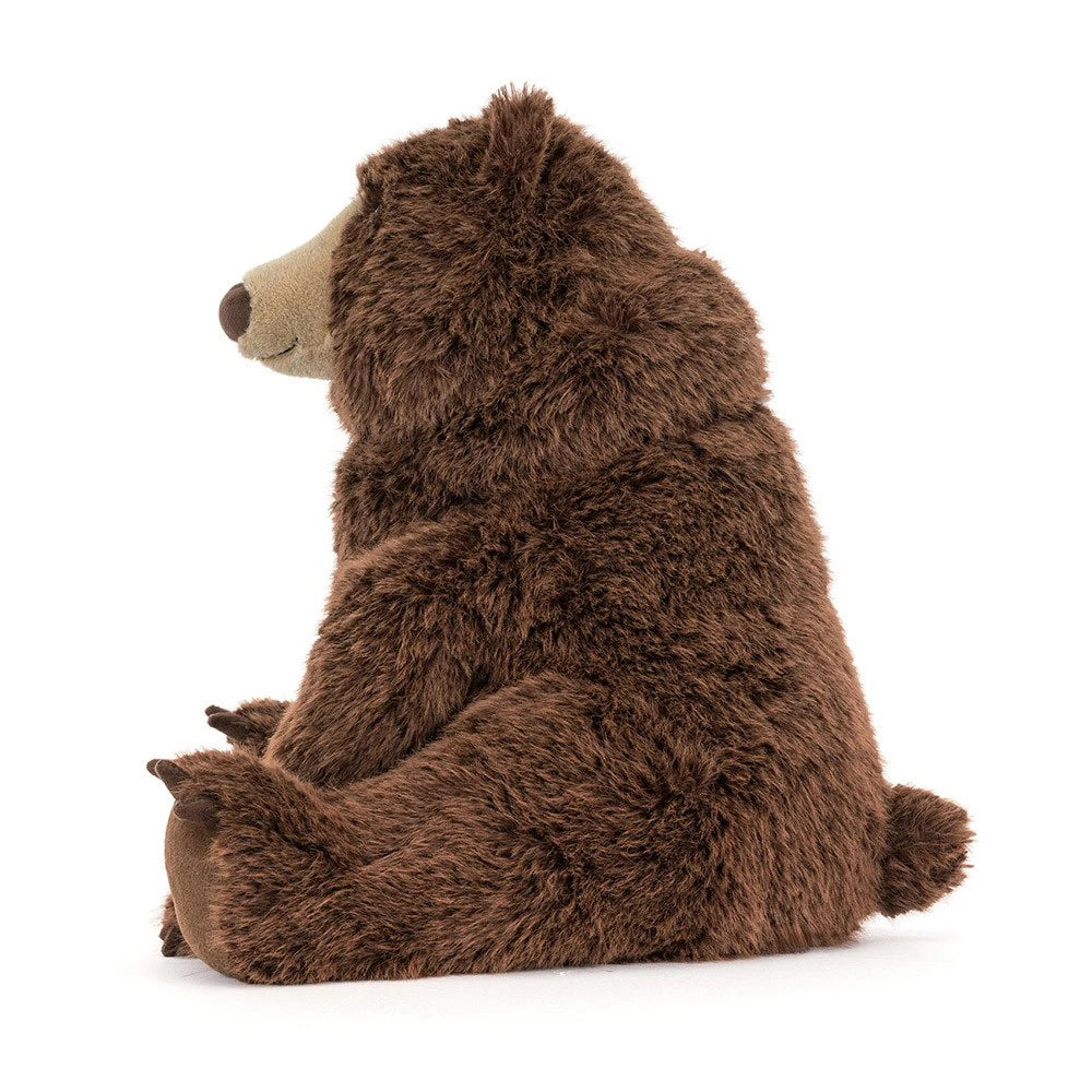 Close-up of JellyCat Bizzlestomp Bear with expressive eyes and soft plush fur