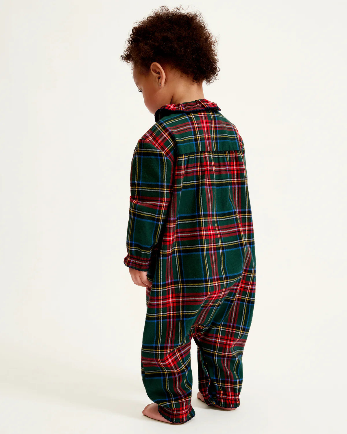 Baby Twill Madeline Romper Kensington Plaid hanging on a stylish hanger, emphasizing its delightful colors and holiday spirit.