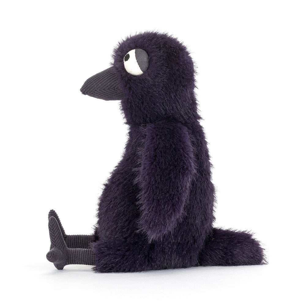 Hocus Crow sitting on a table, showcasing its perfect size for display and cuddles.