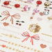 Playful layout of Jewelry Tattoos & Gem Stones by Konges Slojd, showcasing vibrant temporary tattoos with bows, hearts, and intricate details for children's creativity.