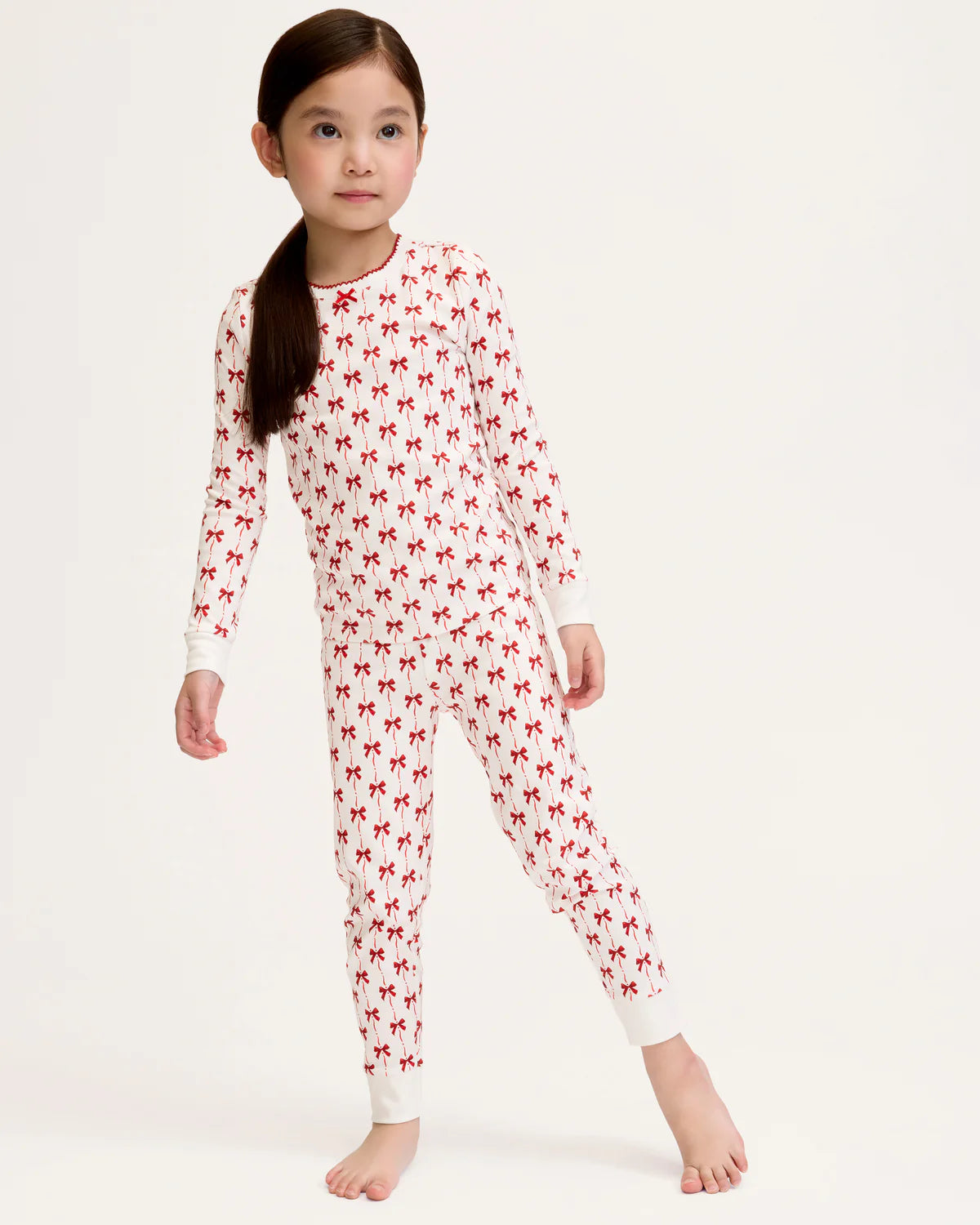 Close-up of Girls Pima Snug Fit Pajama in Blissful Bows showcasing the soft texture and cheerful red bow print.